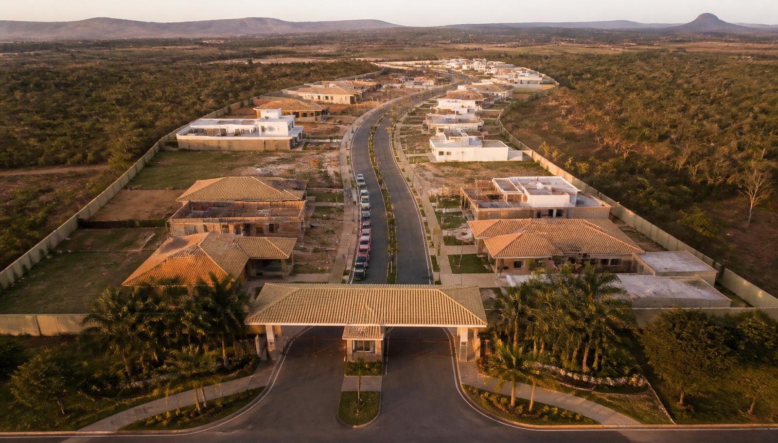 Vista aérea de condomínio fechado horizontal brasileiro com portaria e casas de telhado cerâmico